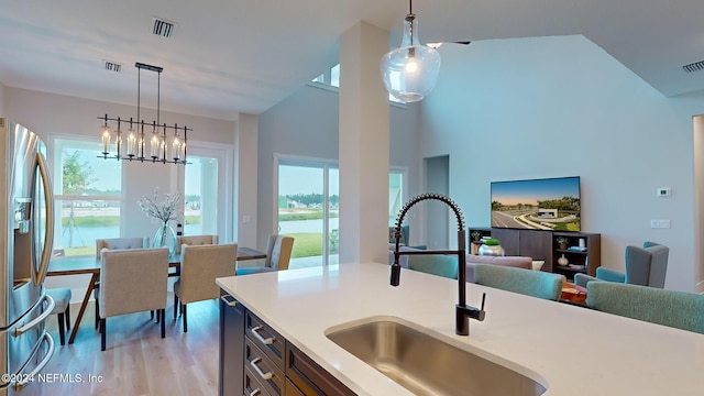 kitchen with a wealth of natural light, stainless steel fridge, visible vents, and a sink