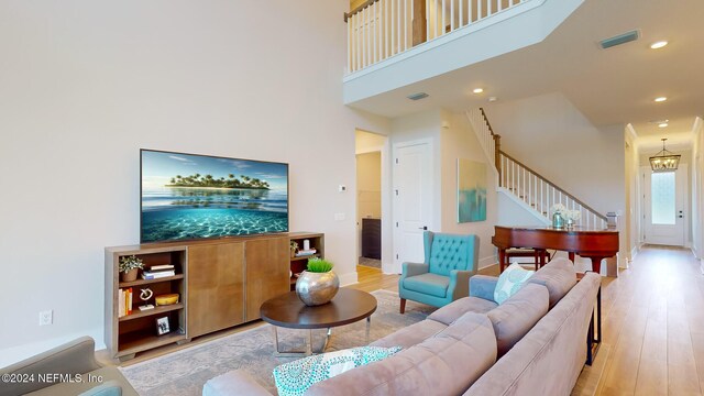 living area featuring light wood-style flooring, stairs, visible vents, and recessed lighting