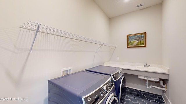 laundry room featuring washing machine and clothes dryer, visible vents, a sink, laundry area, and baseboards