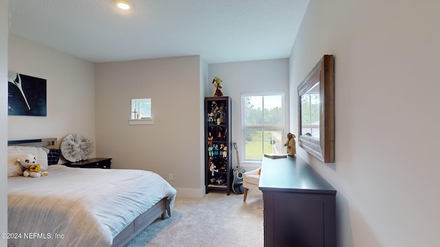 bedroom with baseboards and light colored carpet