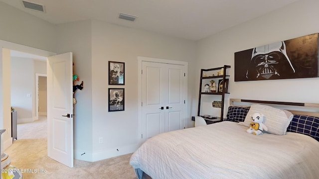 bedroom with baseboards, visible vents, a closet, and light colored carpet