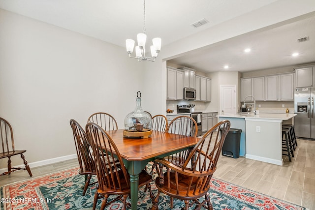 dining space featuring light wood-type flooring and a notable chandelier