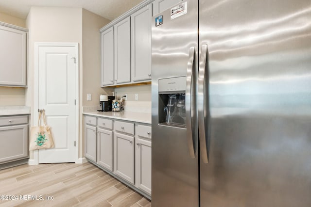 kitchen featuring gray cabinets, light hardwood / wood-style floors, and stainless steel fridge