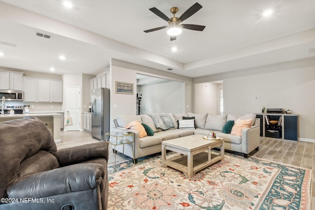 living room with light wood-type flooring and ceiling fan