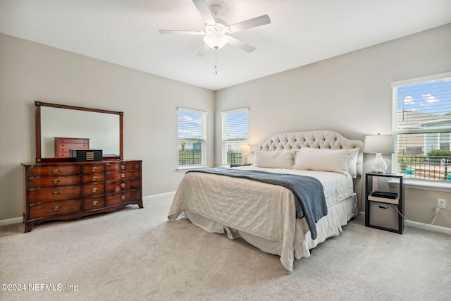 carpeted bedroom with multiple windows and ceiling fan