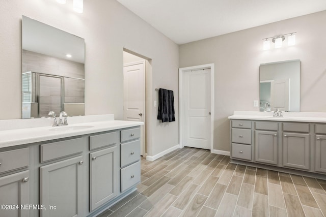 bathroom with a shower with shower door and vanity