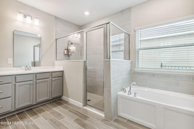 bathroom with vanity and independent shower and bath