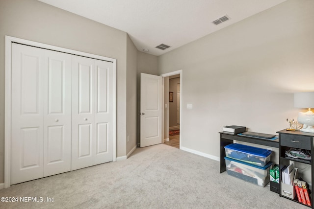 bedroom with light colored carpet and a closet