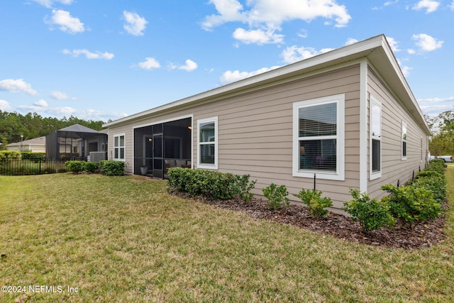 back of house featuring a lawn and a sunroom