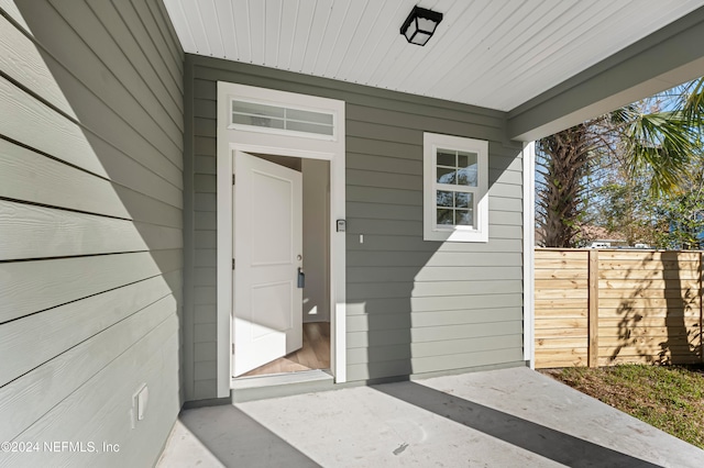 view of exterior entry with a patio area