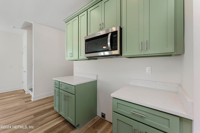 kitchen with light wood-type flooring and green cabinetry