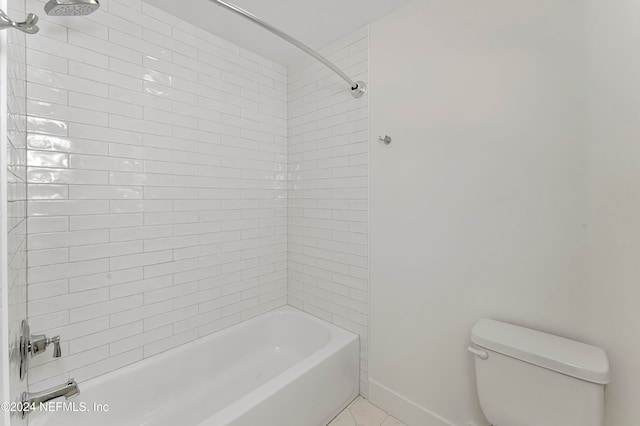 bathroom with tile patterned flooring, tiled shower / bath combo, and toilet