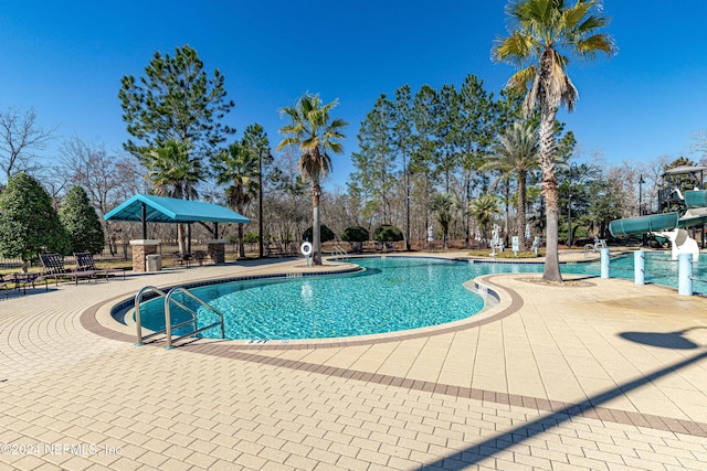 view of swimming pool featuring a patio area and a water slide