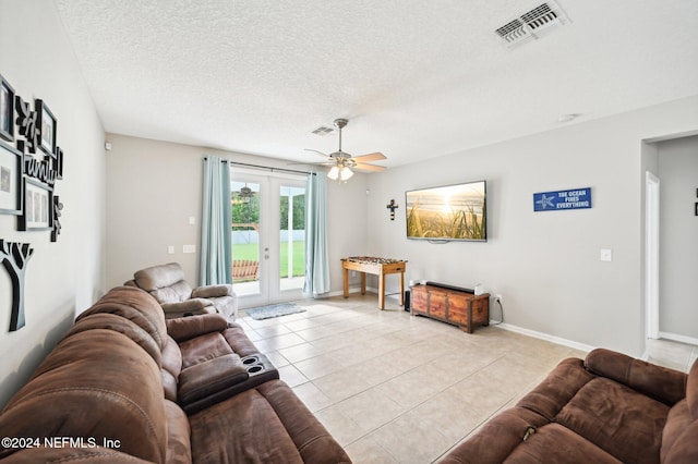 living room with ceiling fan, light tile patterned floors, a textured ceiling, and french doors