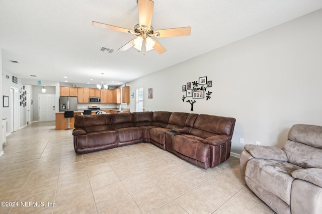 living room featuring light tile patterned flooring and ceiling fan with notable chandelier