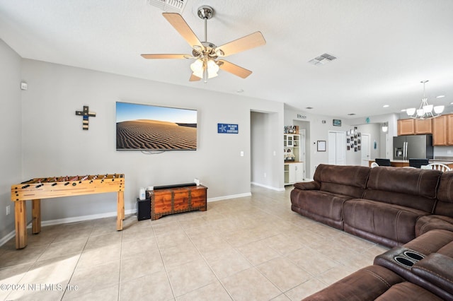 living room featuring light tile patterned flooring and ceiling fan with notable chandelier