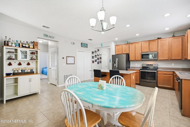 dining space with light tile patterned flooring and an inviting chandelier