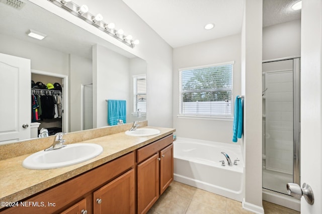 bathroom featuring tile patterned floors, vanity, and separate shower and tub