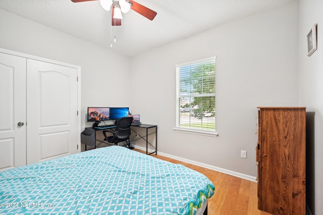 bedroom with light wood-type flooring, a closet, and ceiling fan