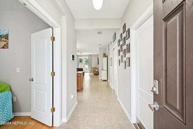 hall with light tile patterned floors