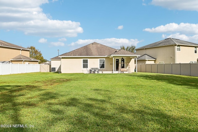 back of property with a patio and a lawn