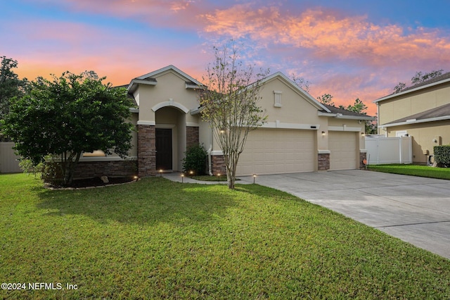 view of front of home featuring a lawn and a garage