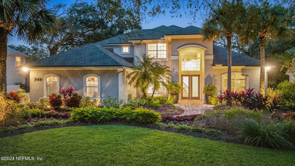 mediterranean / spanish house with french doors and a front lawn