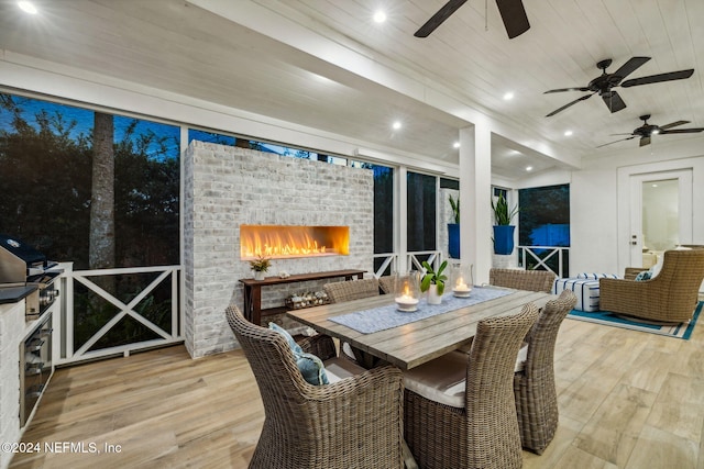 sunroom featuring wooden ceiling and an outdoor brick fireplace