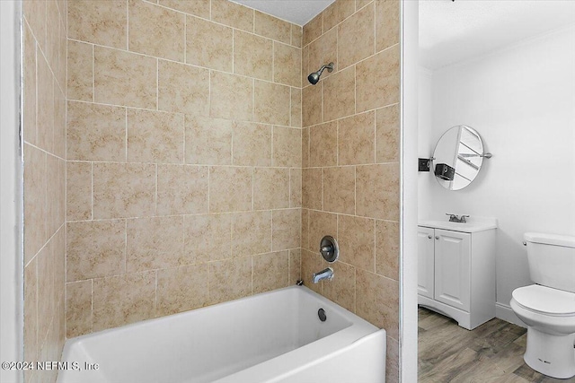 bathroom with toilet, tiled shower / bath combo, and hardwood / wood-style flooring