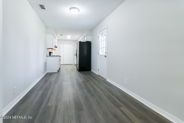 hall featuring a textured ceiling and dark wood-type flooring