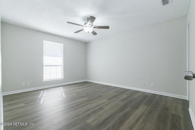 empty room featuring ceiling fan, dark wood-type flooring, and a textured ceiling