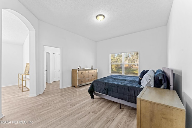 bedroom featuring light hardwood / wood-style flooring and a textured ceiling