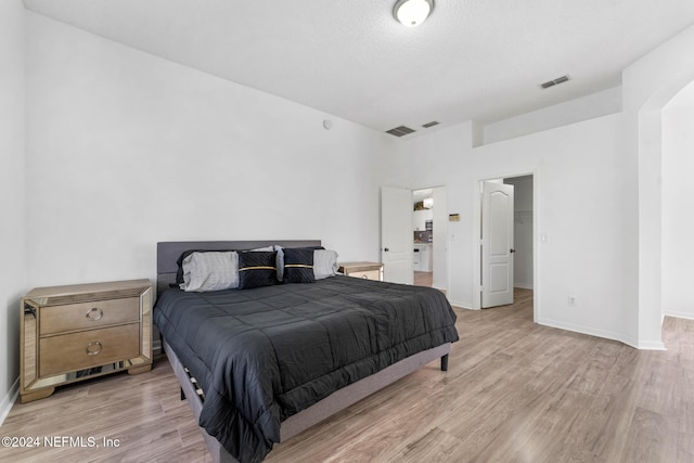 bedroom featuring light hardwood / wood-style floors and a textured ceiling