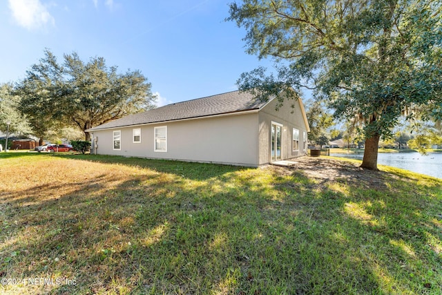 view of property exterior featuring a water view and a yard