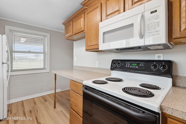 kitchen with ornamental molding, light wood-type flooring, a textured ceiling, and white appliances