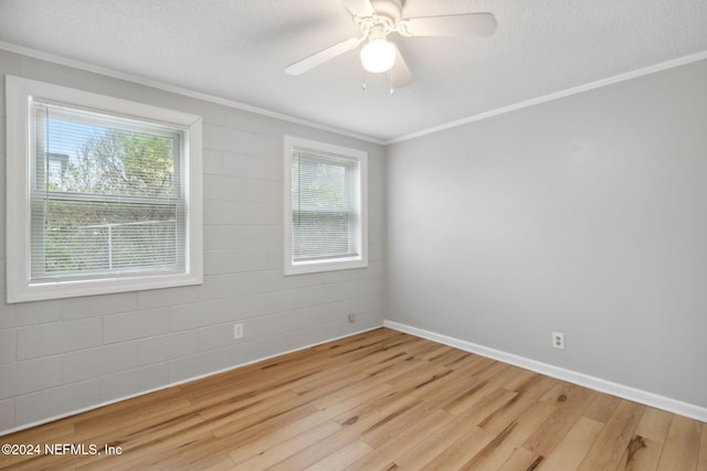 spare room featuring crown molding, light wood-type flooring, a textured ceiling, and ceiling fan