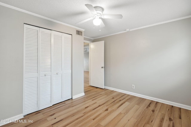 unfurnished bedroom featuring ornamental molding, a closet, ceiling fan, and light hardwood / wood-style floors