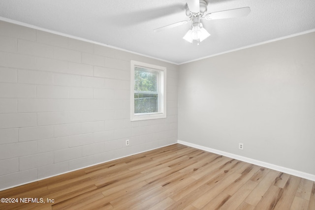 spare room featuring ornamental molding, light hardwood / wood-style floors, a textured ceiling, and ceiling fan