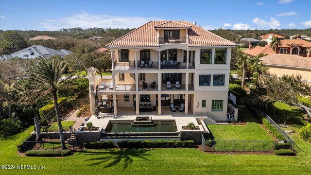 rear view of property featuring a balcony, a yard, a patio, and an outdoor hangout area