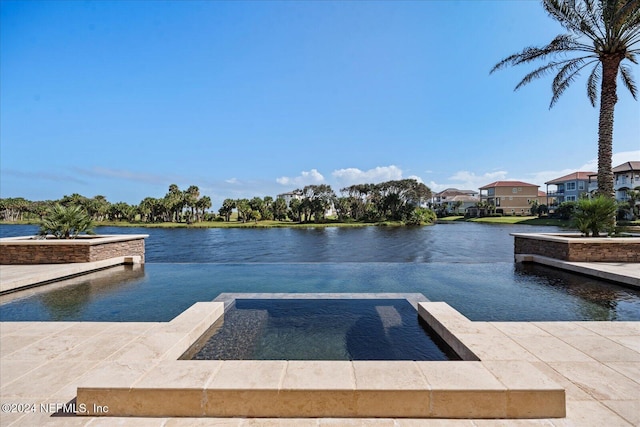 view of pool featuring an in ground hot tub and a water view