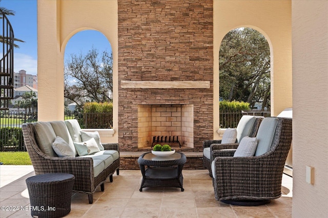 view of patio featuring baseboard heating and an outdoor living space with a fireplace