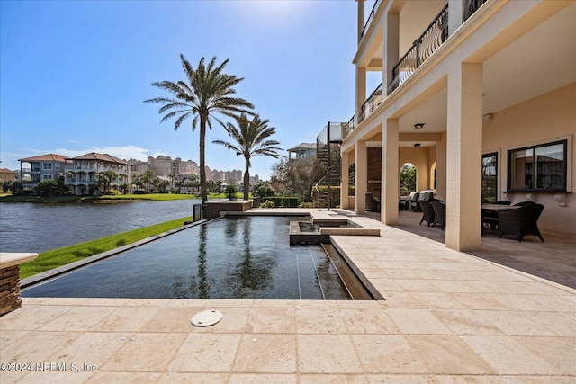 view of pool with a water view and a patio area