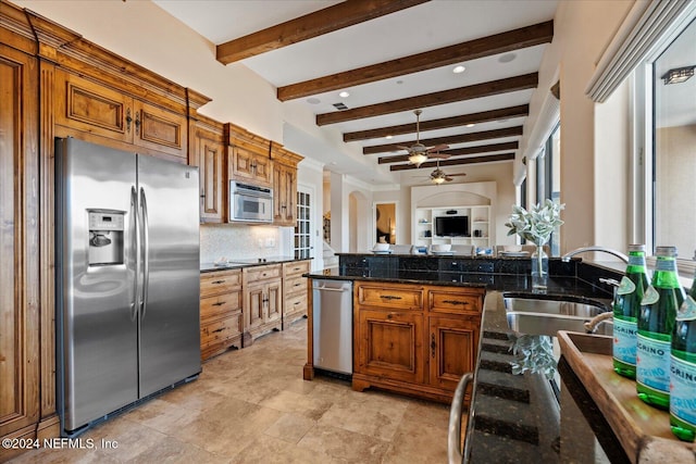 kitchen featuring stainless steel appliances, decorative backsplash, sink, beamed ceiling, and dark stone countertops