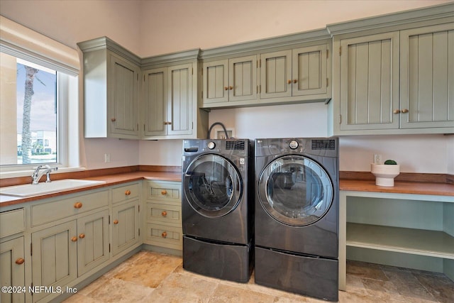 washroom featuring independent washer and dryer, cabinets, and sink