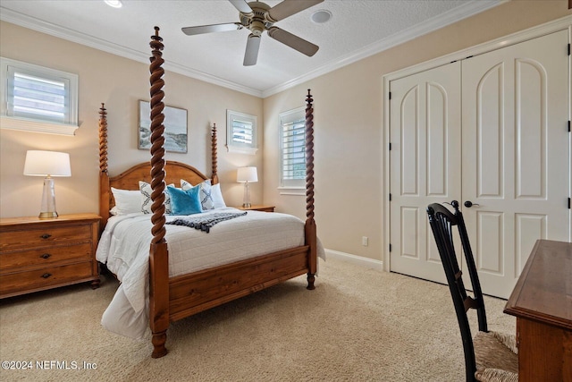 carpeted bedroom featuring ornamental molding, a closet, a textured ceiling, and ceiling fan