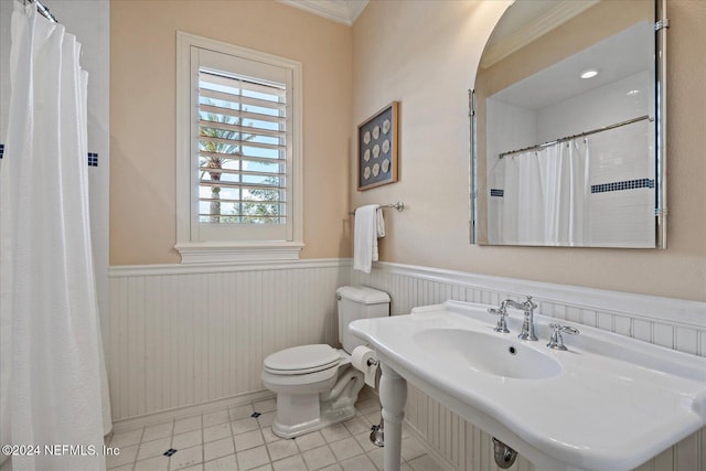 bathroom featuring toilet, sink, curtained shower, and crown molding