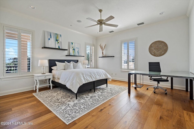 bedroom with hardwood / wood-style flooring, ceiling fan, a textured ceiling, and ornamental molding