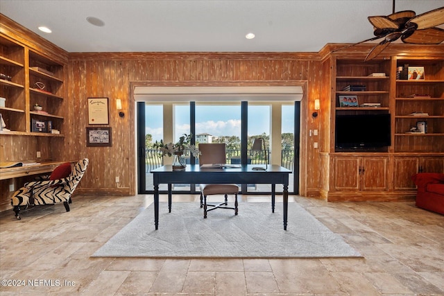 home office with ceiling fan and wooden walls