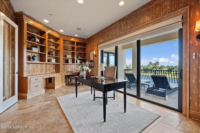 office area with built in features and wood walls