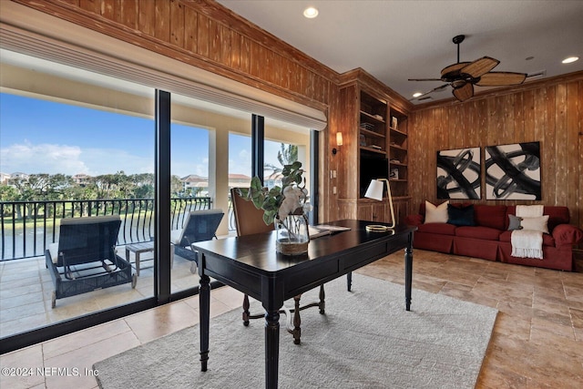 office featuring built in features, wood walls, ornamental molding, and ceiling fan